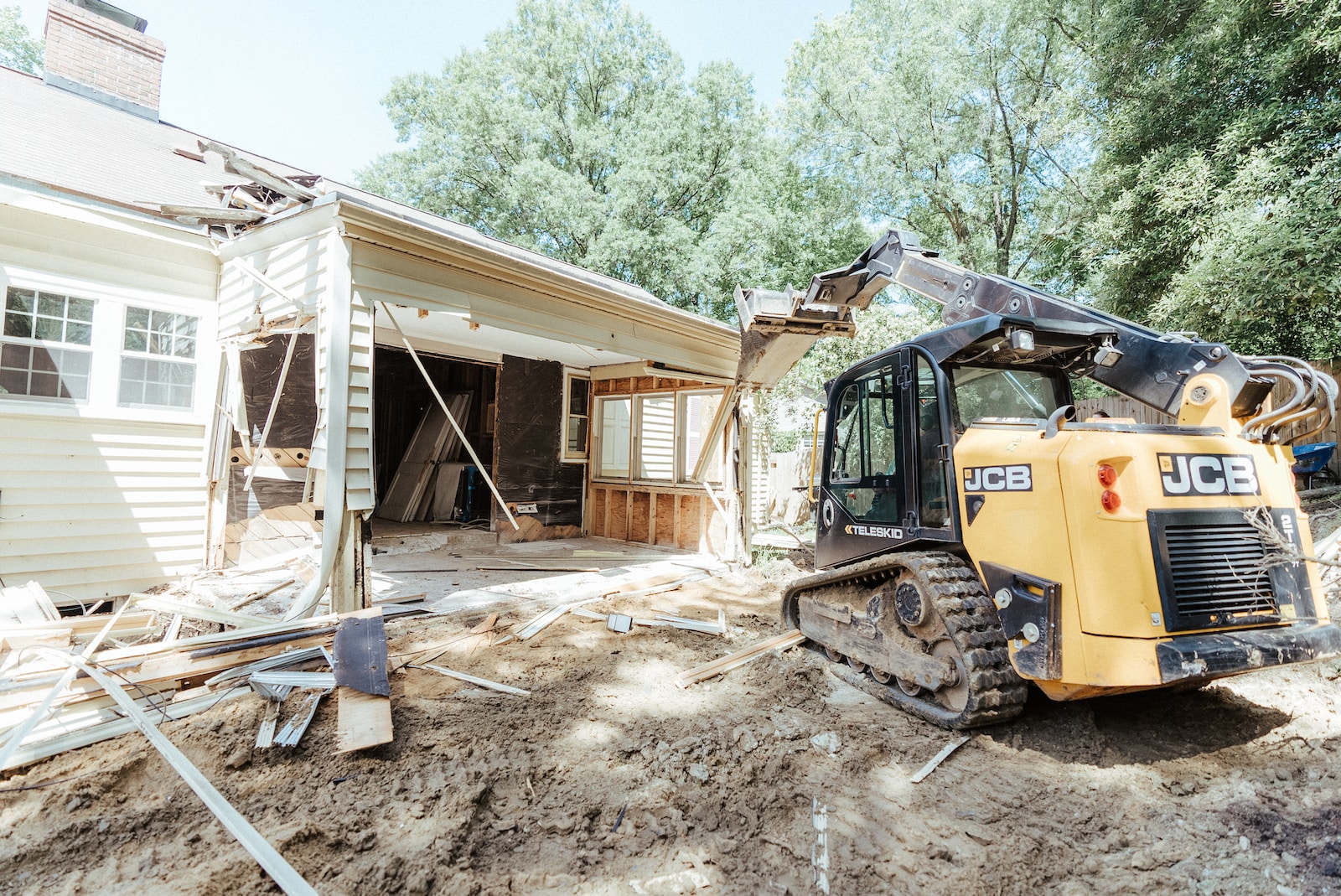 a bulldozer is parked in front of a house - General Contractors Insurance Everett WA