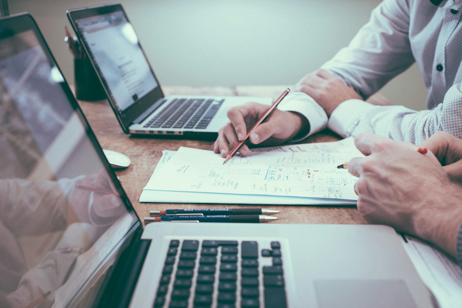 person holding pencil near laptop computer - business insurance quotes The Miller Insurance Agency Everett WA